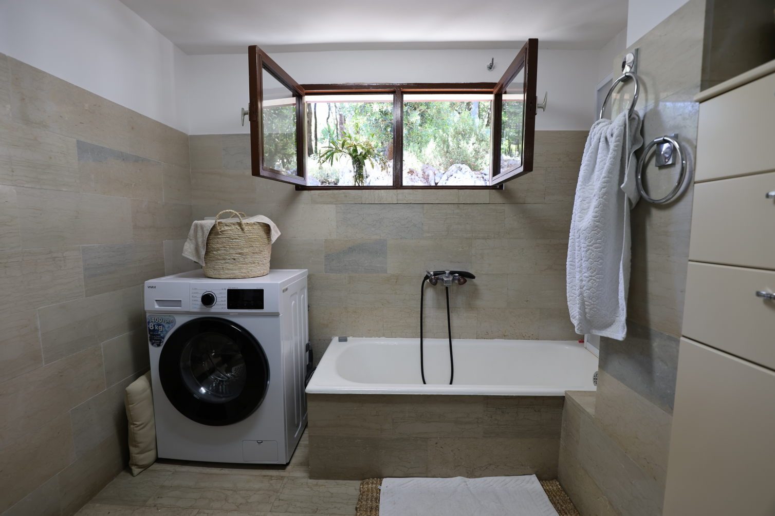 Second bathroom with bathtub and a window onto the garden