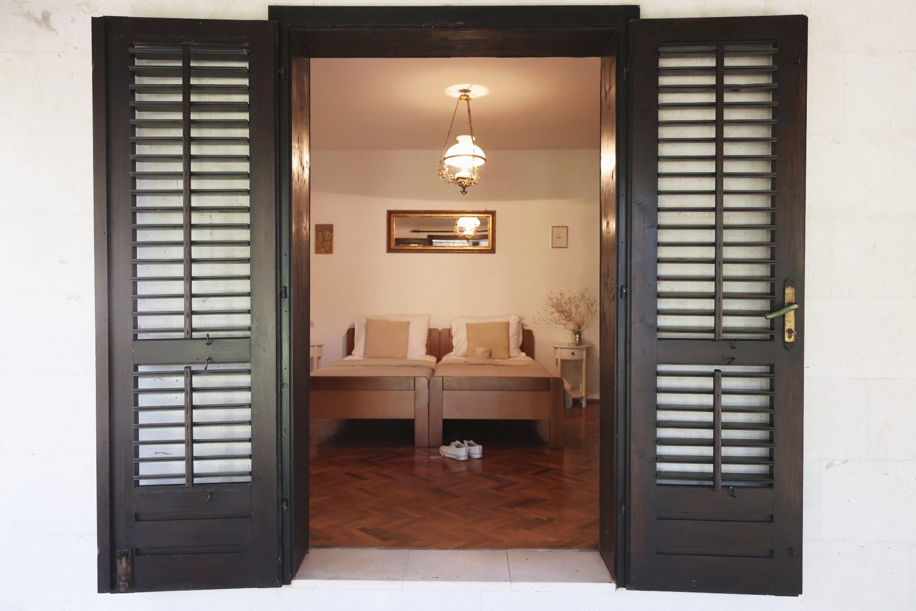 A bedroom seen through dark shutters from the outside