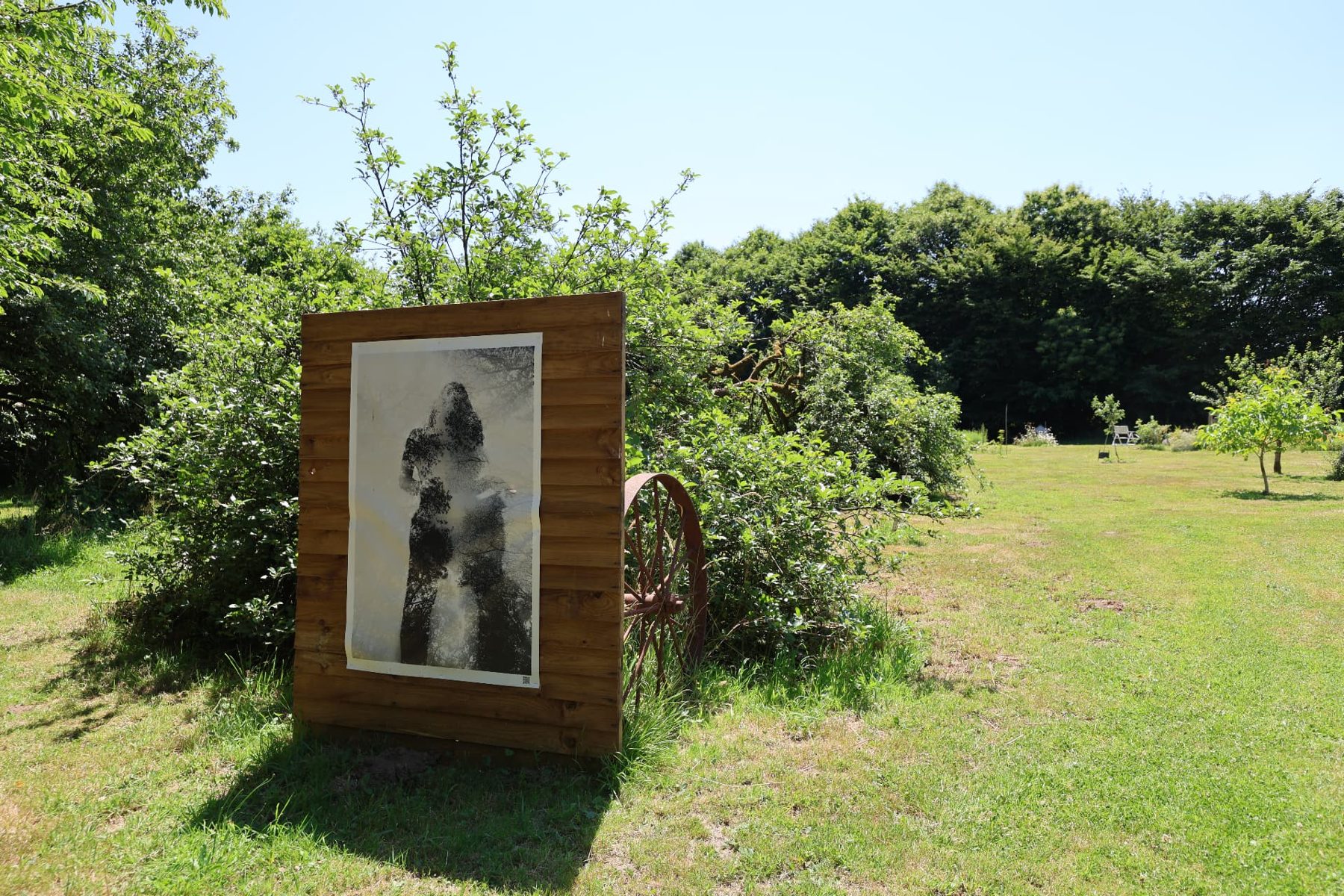 A large black-and-white print on a wooden panel in the garden meadow at Mellionnec
