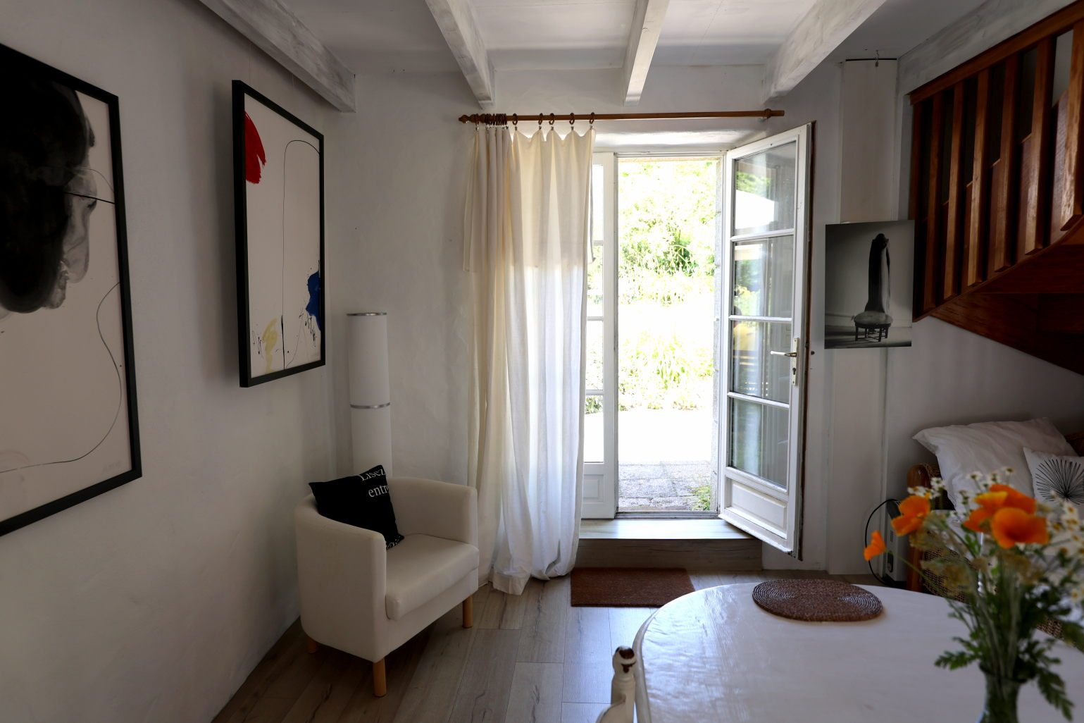 An armchair beside the open glass door onto the garden