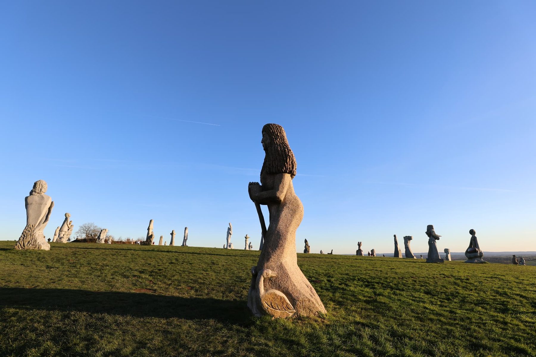 Granite statues of saints on a grassy hill